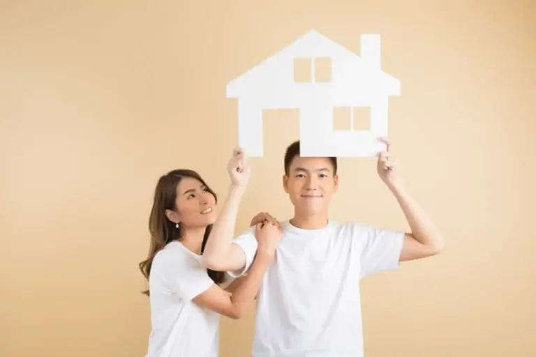 Happy asian couple presenting the symbols of house